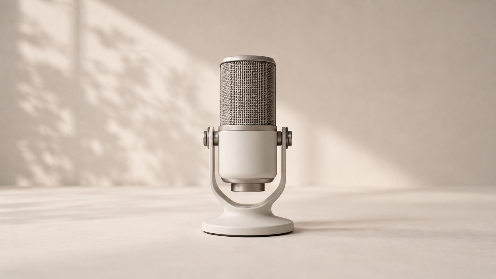 A warm-neutral studio microphone on an integrated stand.